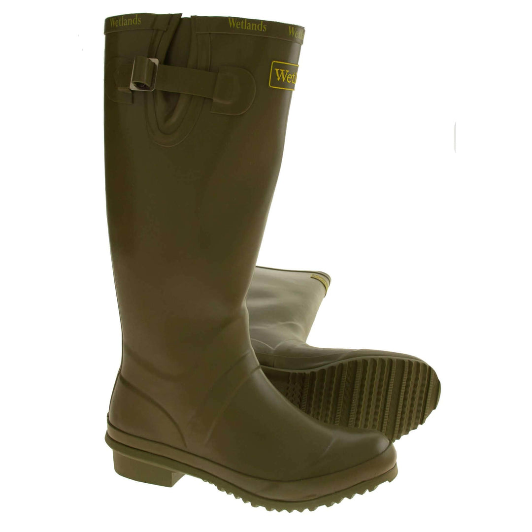 Womens Wellies. Green rubber waterproof wellington boots. Just below knee height. With a small heel and deep tread to the sole. Yellow Wetlands Brand to the front of the boot near the top. Brighter green Wetlands written numerous times around the rim of the boot. Side strap with buckle to adjust the calf width. Textile lining to the inside of the boot. Both boots from side profile with the left foot on its side to show the sole.