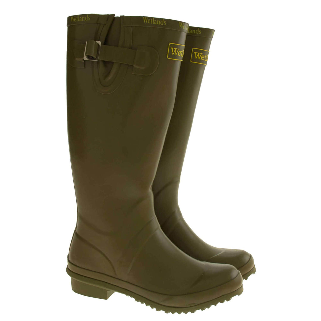 Womens Wellies. Green rubber waterproof wellington boots. Just below knee height. With a small heel and deep tread to the sole. Yellow Wetlands Brand to the front of the boot near the top. Brighter green Wetlands written numerous times around the rim of the boot. Side strap with buckle to adjust the calf width. Textile lining to the inside of the boot. Both boots next to each other from the side.