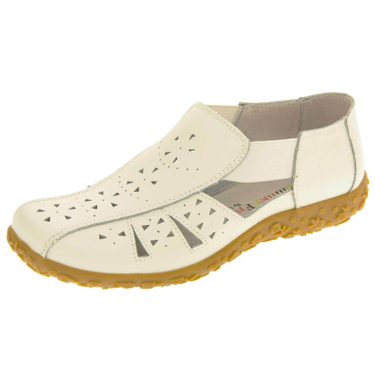 Womens white sandals. White leather closed toe sandals with white stitched detailing. With small cut out details on the upper. White elasticated strips from tongue to ankle to allow more room for a better fit. Cream coloured leather insole and lining. Brown sole with raised flower design for grip. Left foot at an angle.