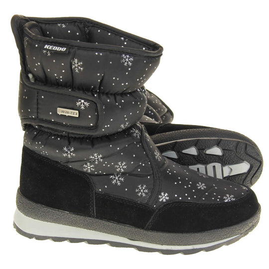 Womens Winter Boots. Black textile upper with snowflake and dots pattern on in white. Black faux-suede edging to the bottom of the boot . Grey and white chunky sole with good grip. Faux fur lining. Silver metal Win-Tex tag on the touch fasten strap, Keddo label along outside rim of the foot. Both feet from side profile with the left foot on its side to show the sole.