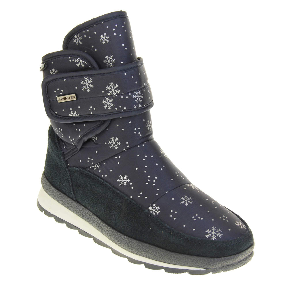 Womens Winter Boots. Navy blue textile upper with snowflake and dots pattern on in white. Dark blue faux-suede edging to the bottom of the boot . Grey and white chunky sole with good grip. Faux fur lining. Silver metal Win-Tex tag on the touch fasten strap, Keddo label along outside rim of the foot. Right foot at an angle.